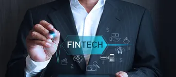 A businessman touching a glowing FinTech interface