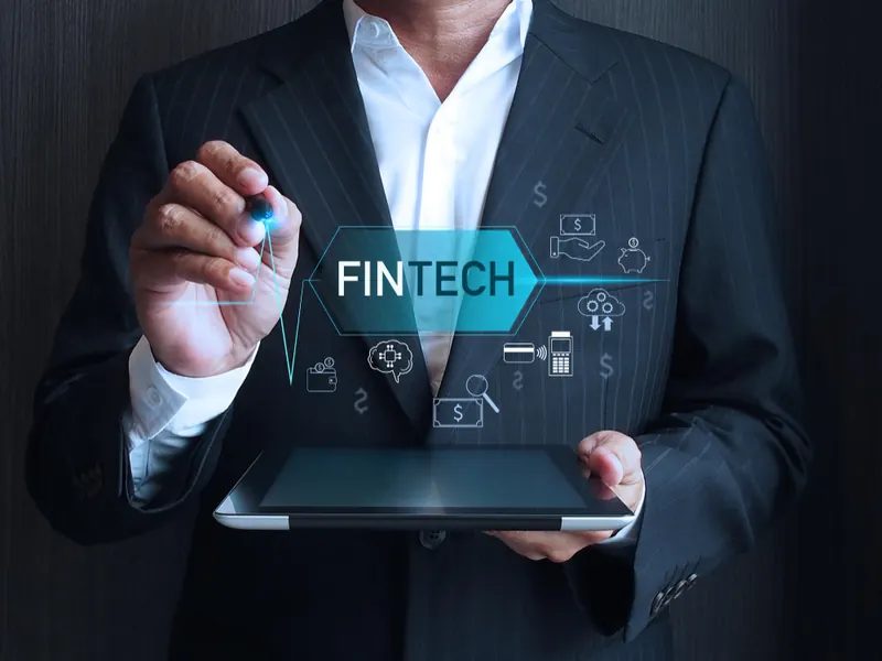 A businessman touching a glowing FinTech interface
