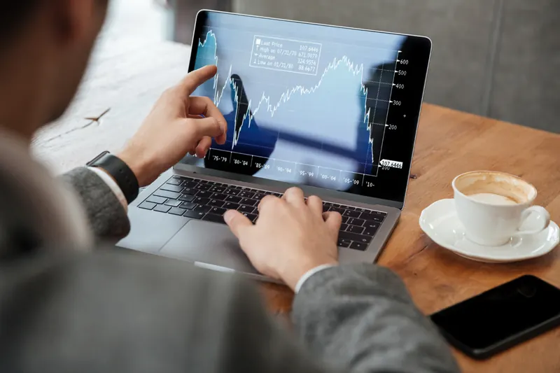 A laptop showing stock market charts on a desk