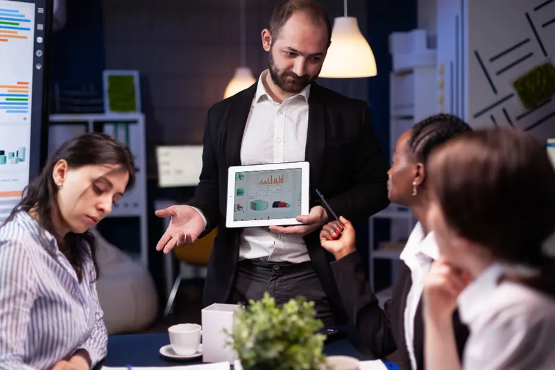 Colleagues reviewing a dashboard on a tablet in a meeting