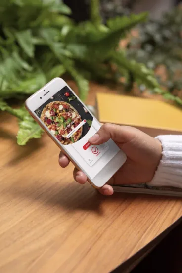 Hand holding a phone showing a pizza order