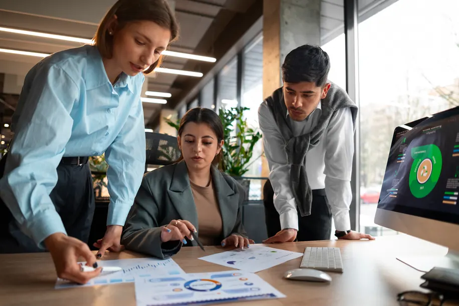 A product team reviewing reports and charts together at a desk