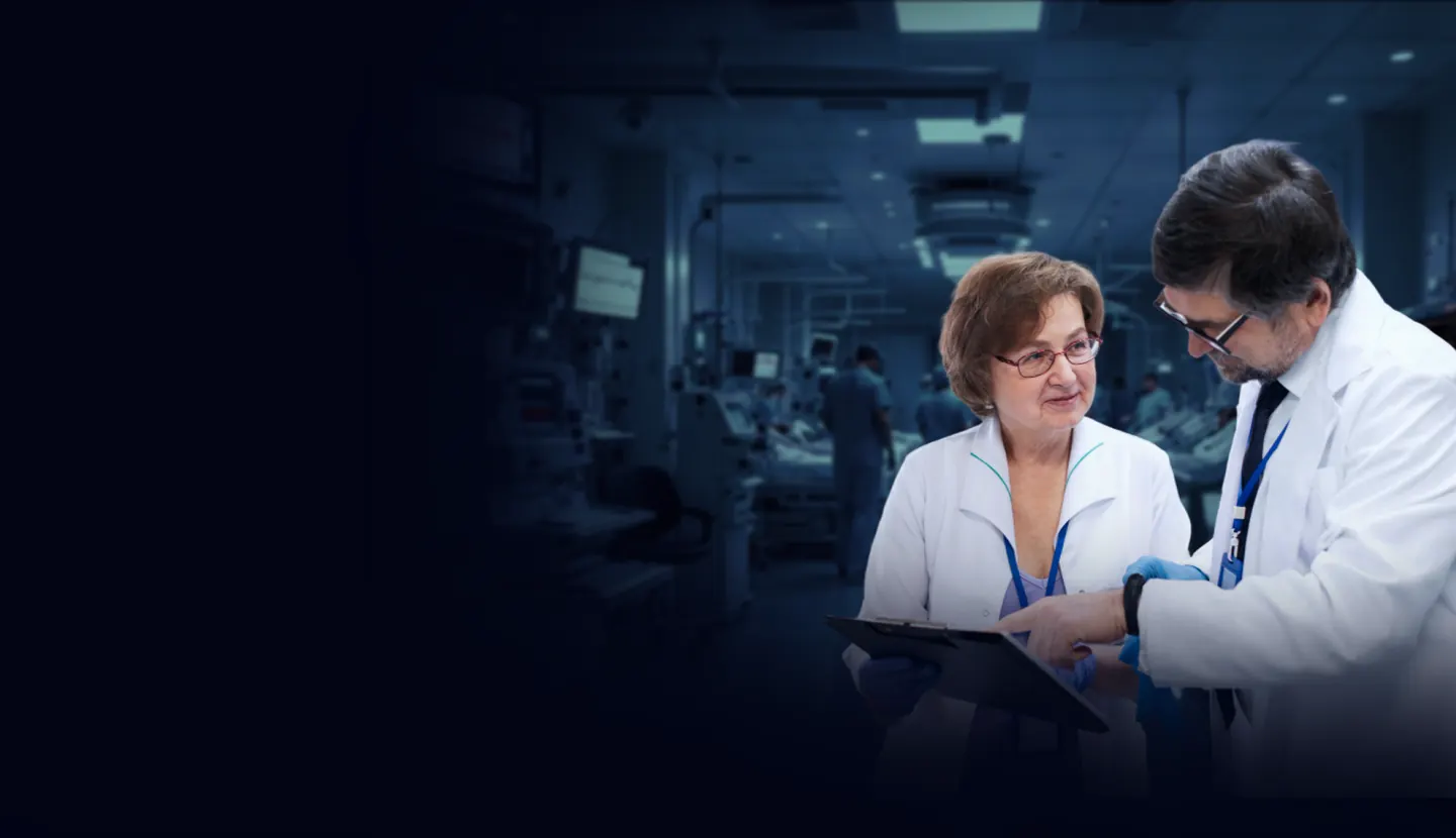 Two doctors reviewing a patient's chart together in a hospital ward