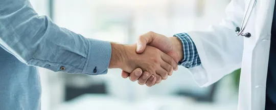 A patient shaking hands with a doctor