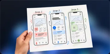 A hand holding printed wireframes of three iPhone screen designs